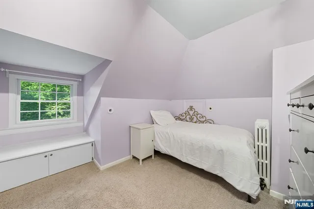 a view of a bedroom with a bed and a window