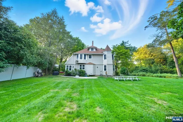 a view of a big house with a big yard and large trees