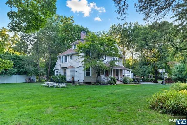 a front view of a house with a garden and trees