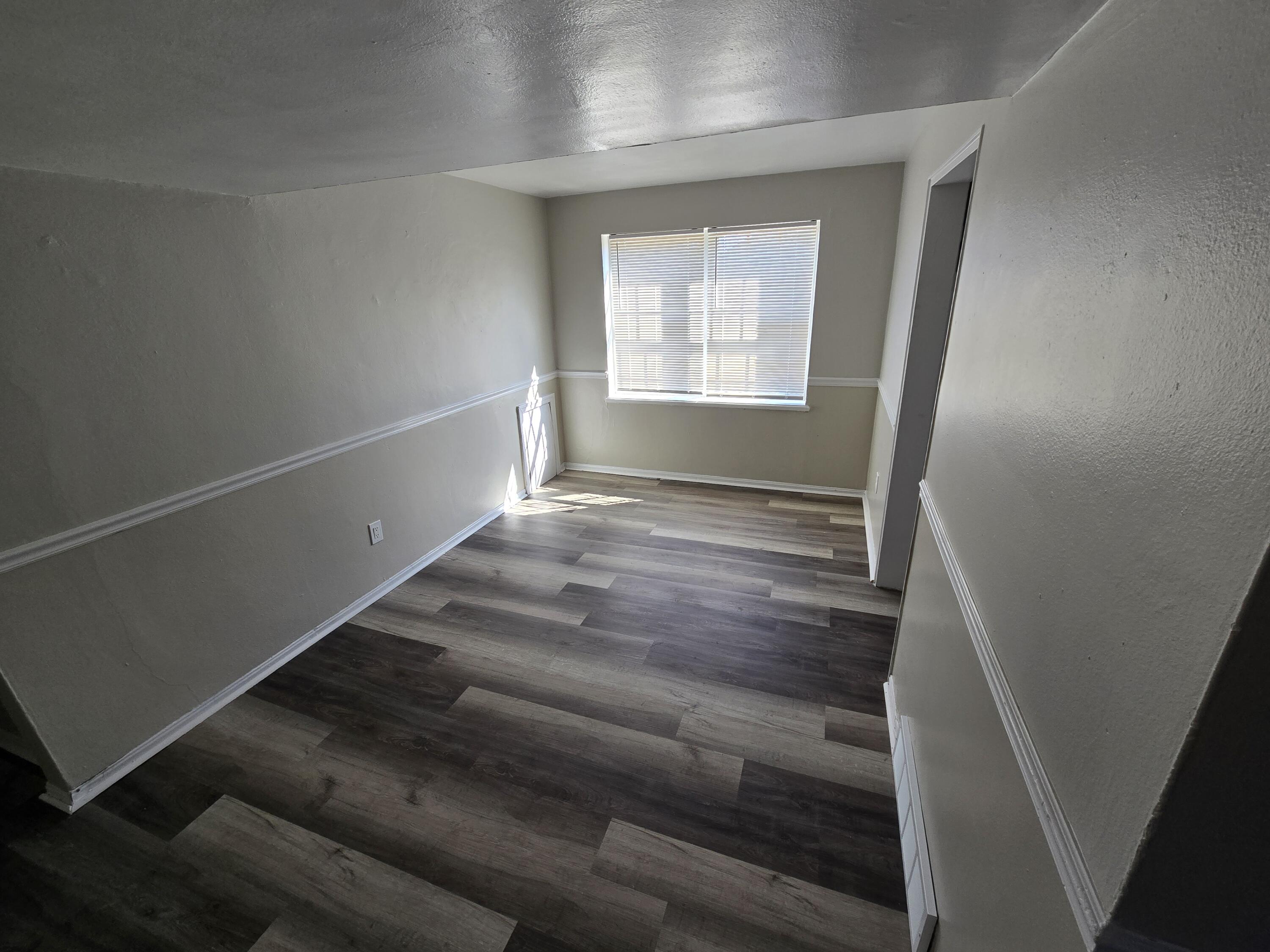 1720 Grandin Road Southwest, Unit 21 Roanoke, VA 24015 - Photo 3 of 6 a view of an empty room with wooden floor and a window