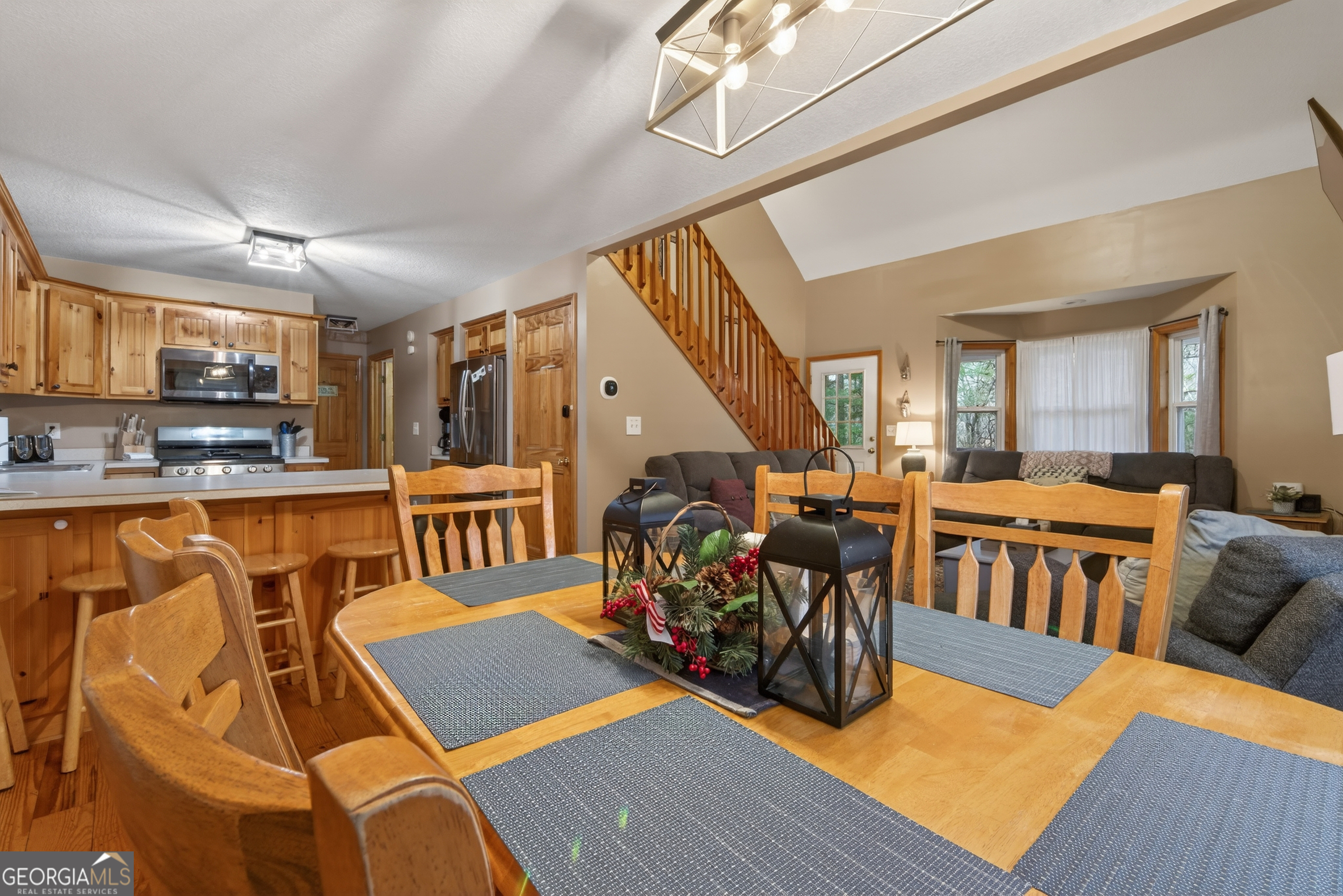 697 Zeppelin Strasse Helen, GA 30545 - Photo 12 of 56 a living room with lots of furniture and a dining table with wooden floor