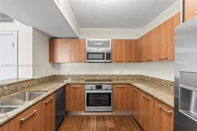 a kitchen with granite countertop wooden cabinets and white appliances