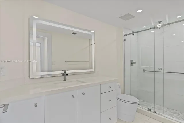 a bathroom with a toilet a sink a mirror and vanity