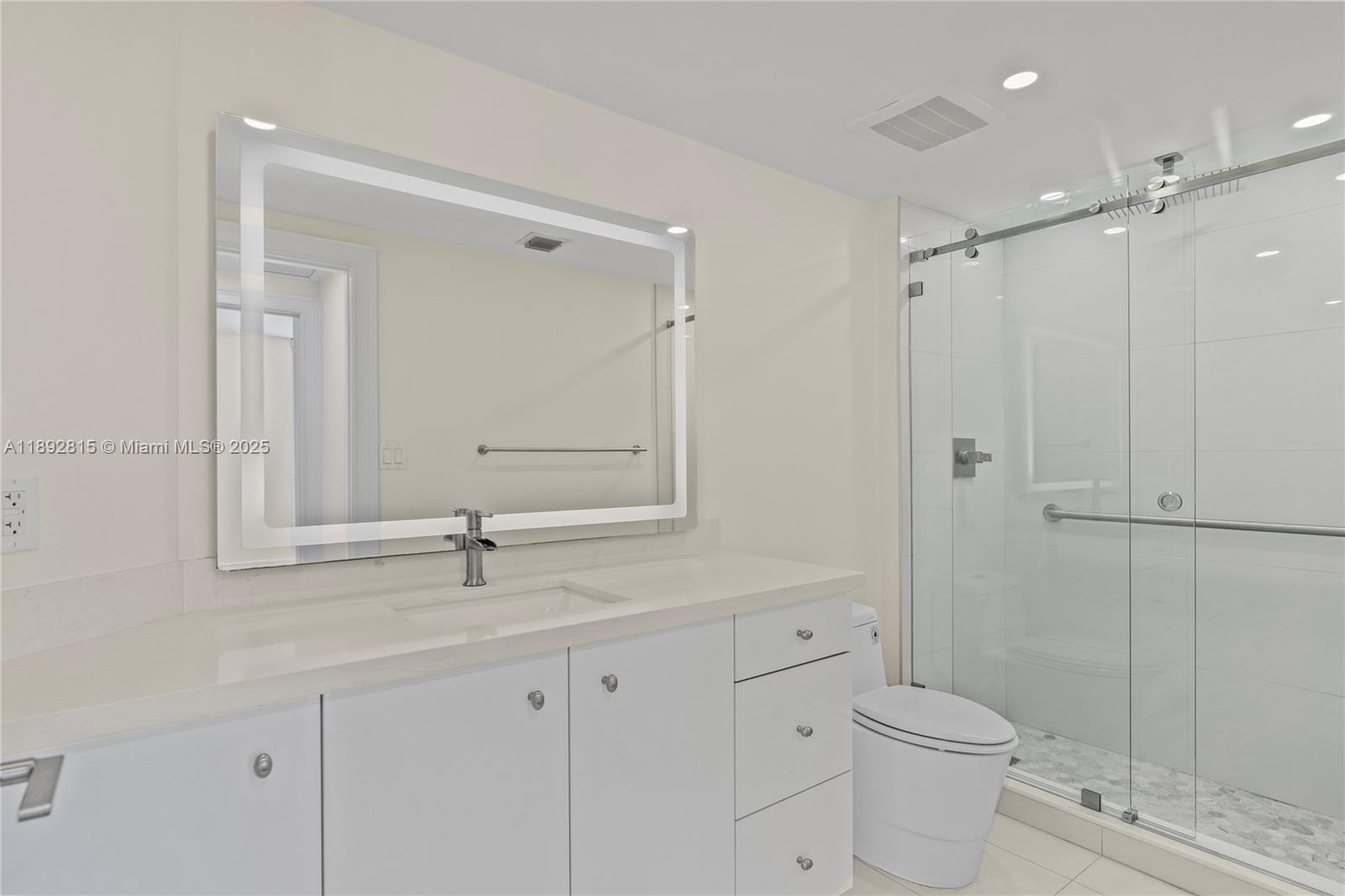 9055 Southwest 73rd Court, Unit 1502 Miami, FL 33156 - Photo 6 of 41 a bathroom with a toilet a sink a mirror and vanity