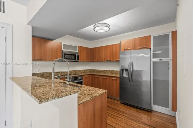 a kitchen with granite countertop a refrigerator and a sink