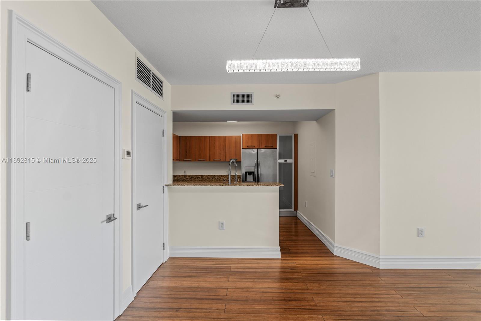 9055 Southwest 73rd Court, Unit 1502 Miami, FL 33156 - Photo 10 of 41 a room view with wooden floor and white doors