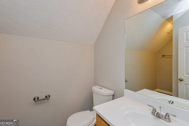 a bathroom with a sink a toilet and a mirror