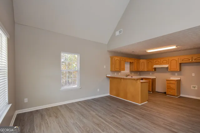 a kitchen with granite countertop a stove top oven sink and cabinets