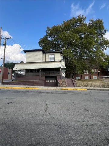 a view of house with swimming pool and a yard