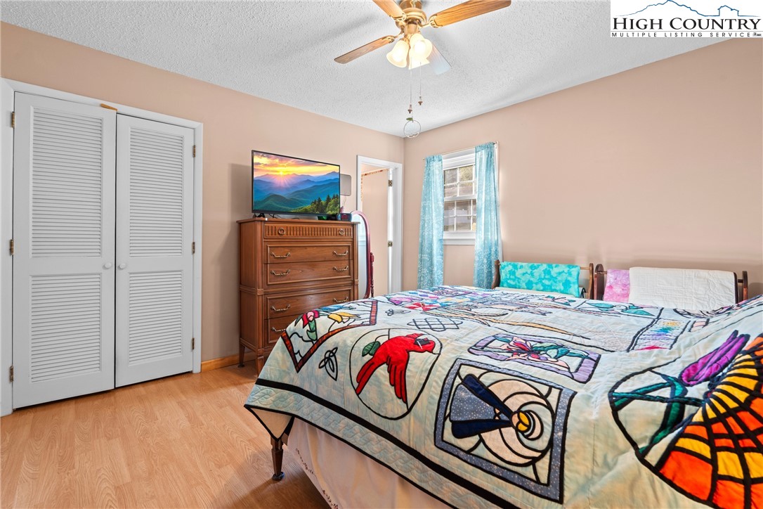 2598 Conner Circle Lenoir, NC 28645 - Photo 22 of 35 a bedroom with a bed a dresser and potted plants