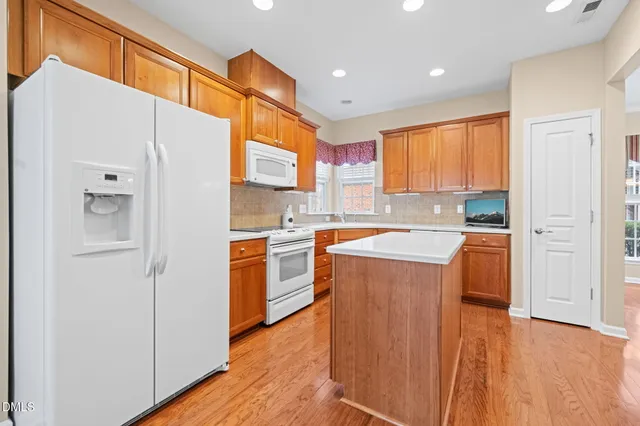 a kitchen with stainless steel appliances a refrigerator a sink dishwasher with a stove and wooden floor