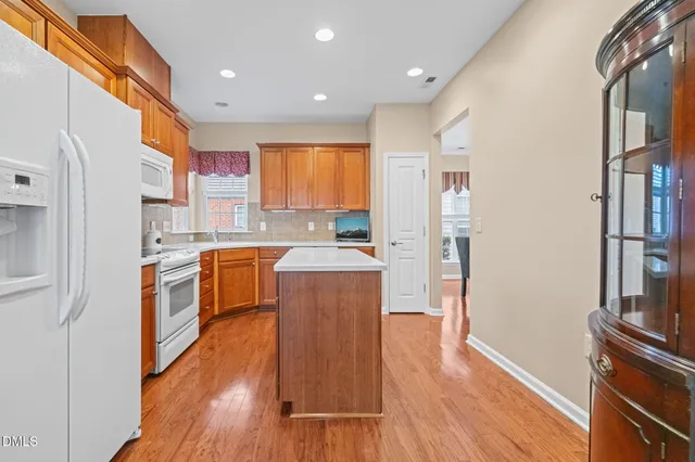 a kitchen with kitchen island granite countertop wooden floors and stainless steel appliances