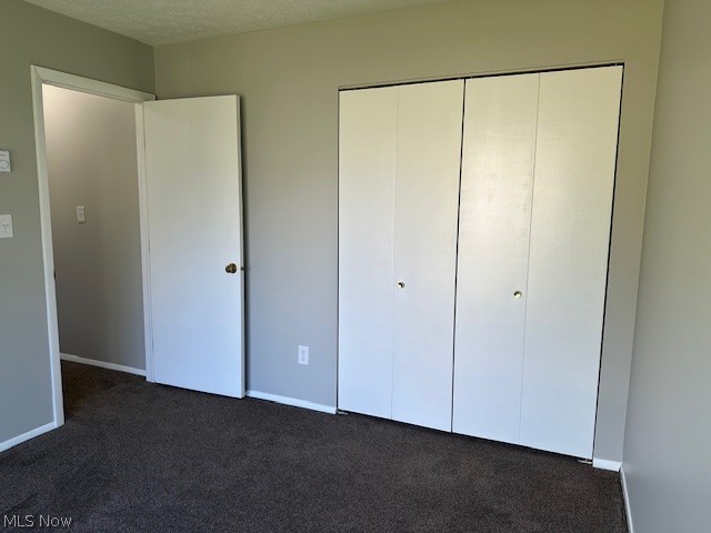 4376 Darrow Road, Unit 7 Stow, OH 44224 - Photo 14 of 23 Unfurnished bedroom with dark carpet, a closet, and a textured ceiling