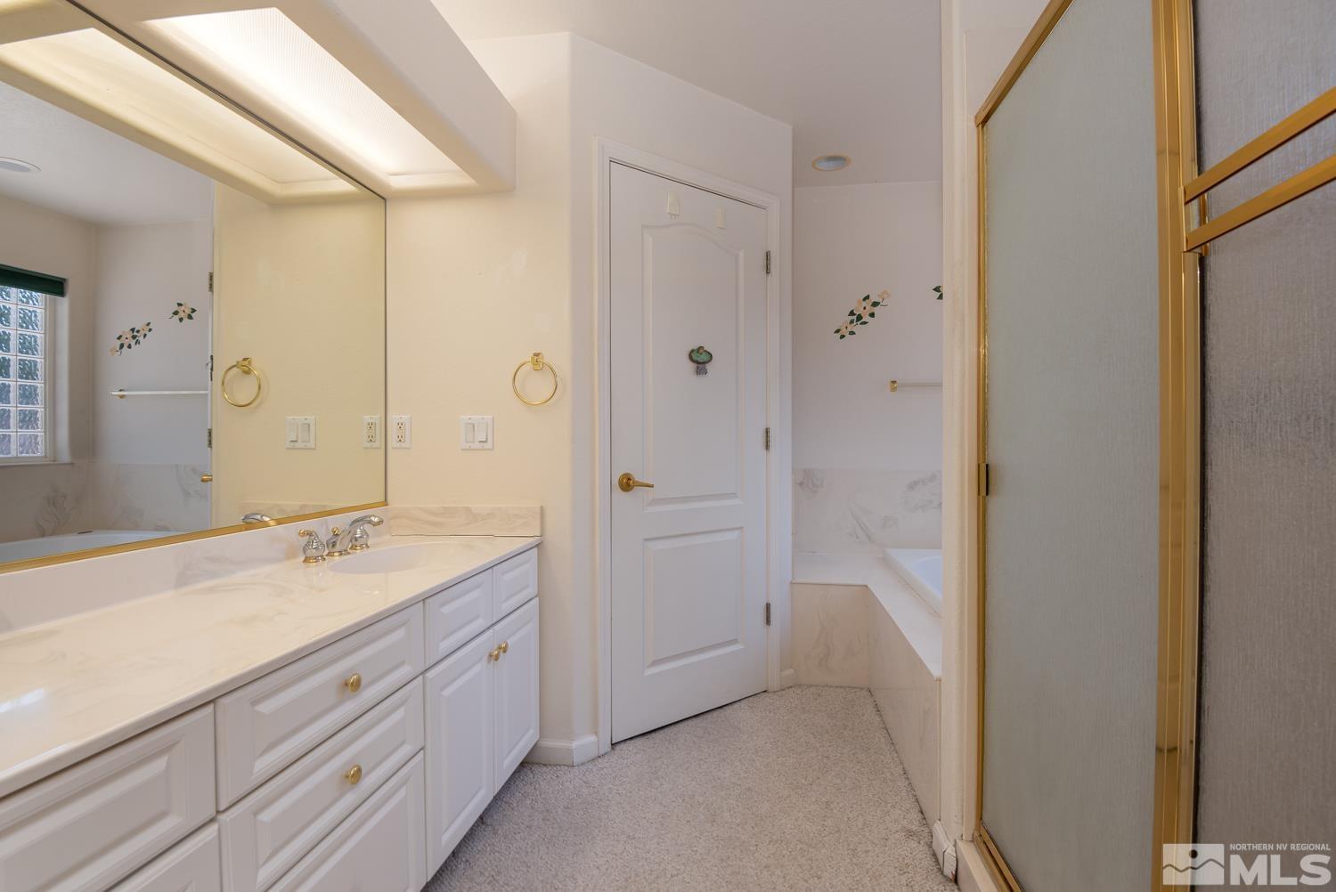 877 Longleaf Place Minden, NV 89423 - Photo 21 of 39 a spacious bathroom with a granite countertop sink mirror and a