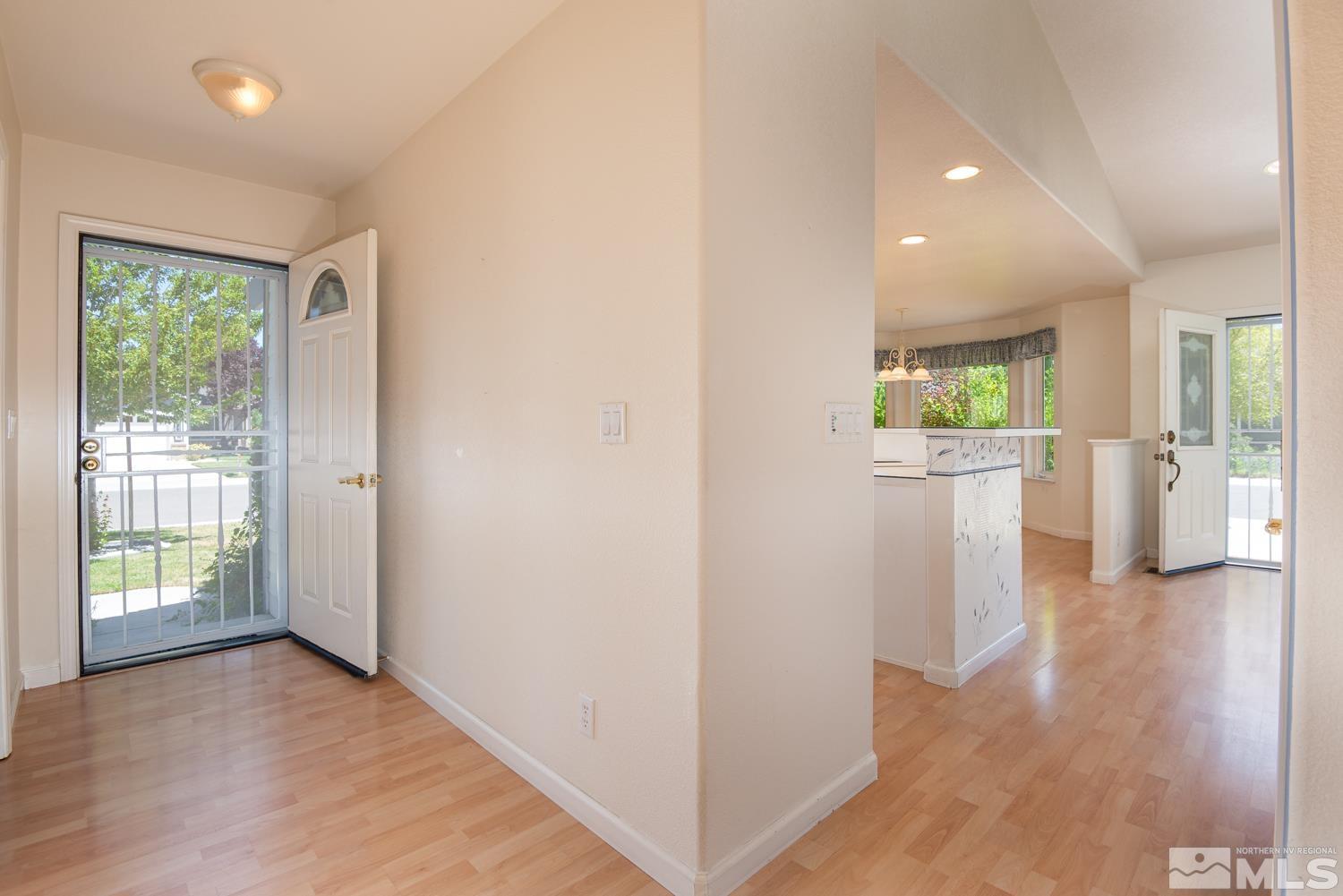 877 Longleaf Place Minden, NV 89423 - Photo 3 of 39 a view of an empty room with wooden floor and a window