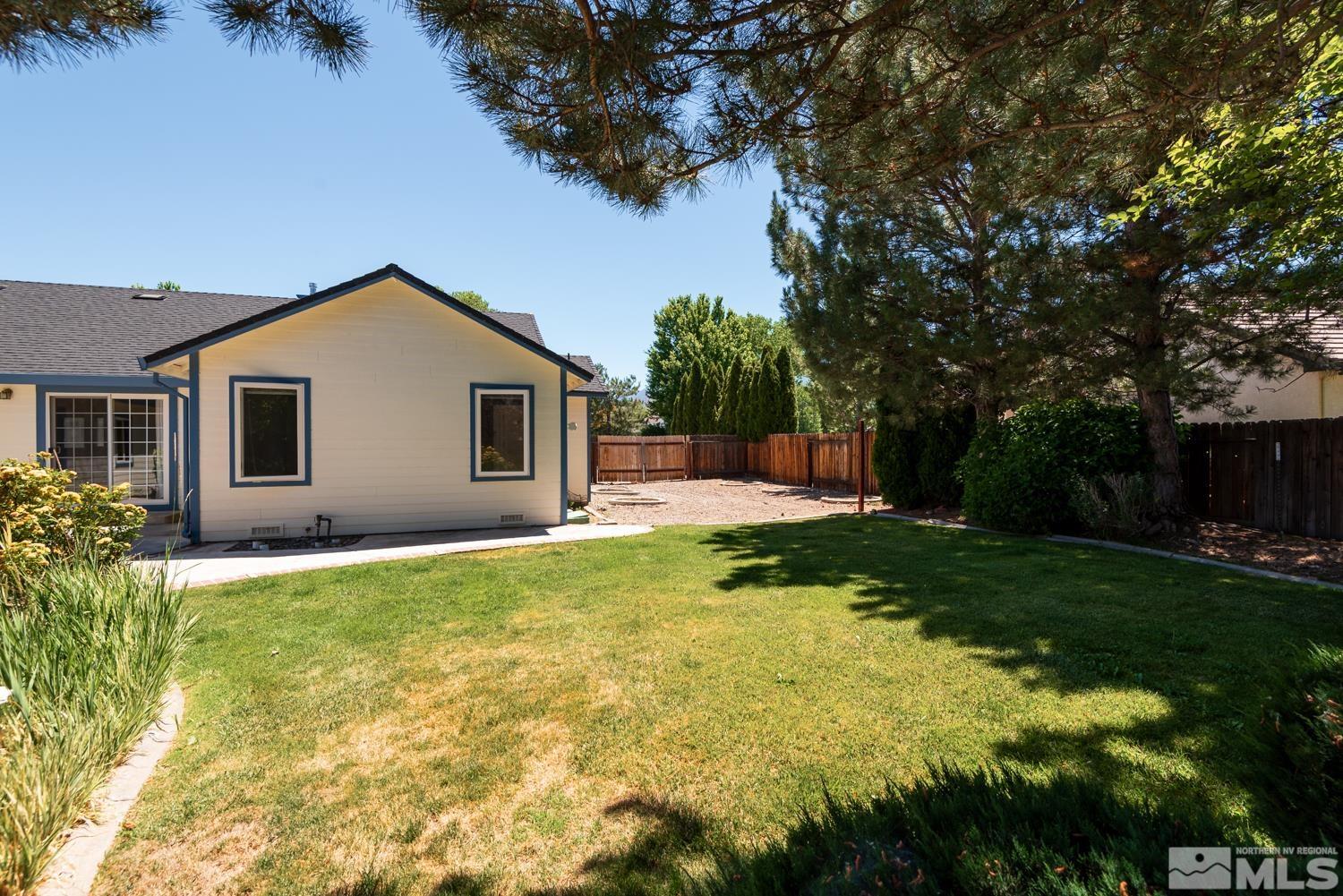 877 Longleaf Place Minden, NV 89423 - Photo 37 of 39 a backyard of a house with table and chairs plants and large tree