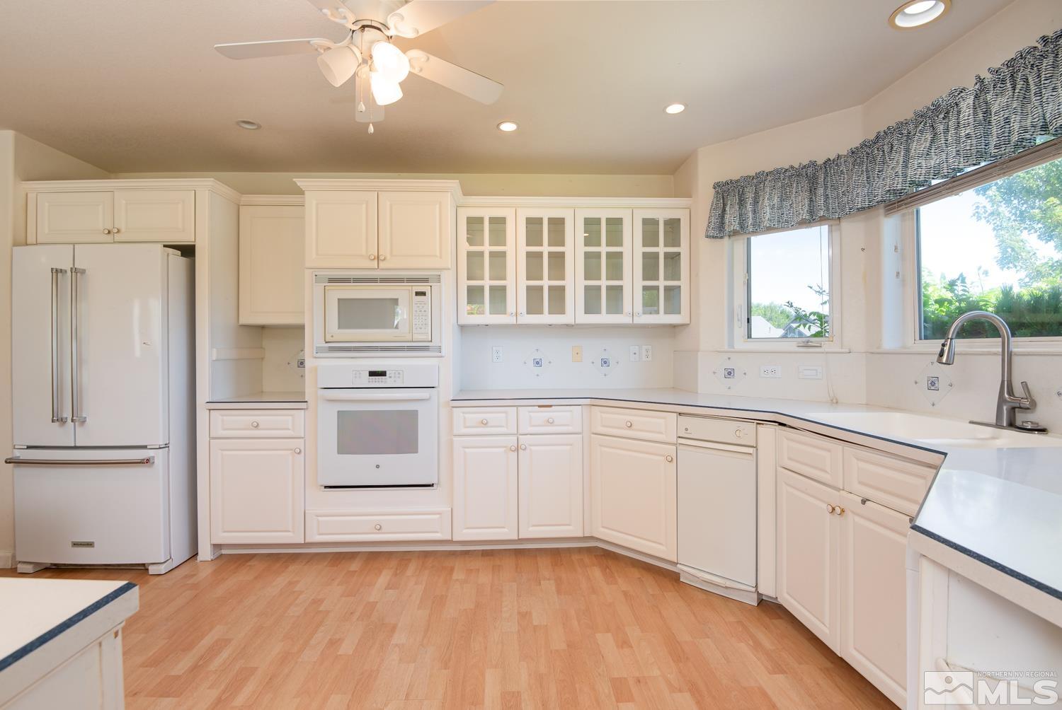 877 Longleaf Place Minden, NV 89423 - Photo 7 of 39 a kitchen with white cabinets and white appliances