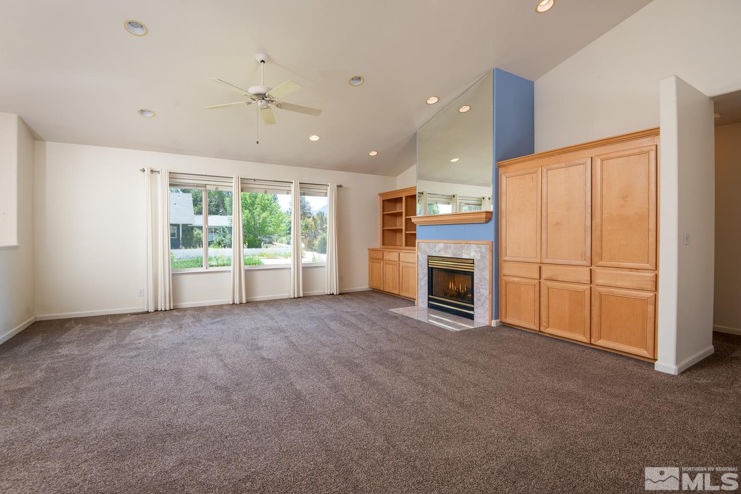 877 Longleaf Place Minden, NV 89423 - Photo 8 of 39 a view of an empty room with a fireplace and a window