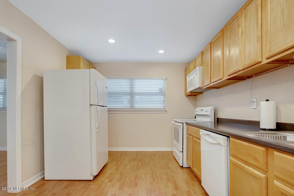 760 Triton Road Atlantic Beach, FL 32233 - Photo 11 of 24 a kitchen with stainless steel appliances granite countertop a refrigerator a sink dishwasher a stove and white countertops with wooden floor