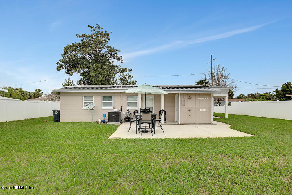 760 Triton Road Atlantic Beach, FL 32233 - Photo 19 of 24 a view of a patio with table and chairs potted plants and a large tree
