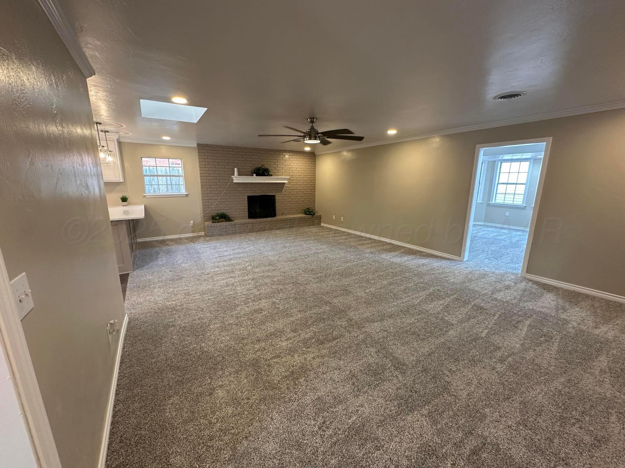 4402 Gary Lane Amarillo, TX 79110 - Photo 2 of 19 an empty room with windows and a fireplace