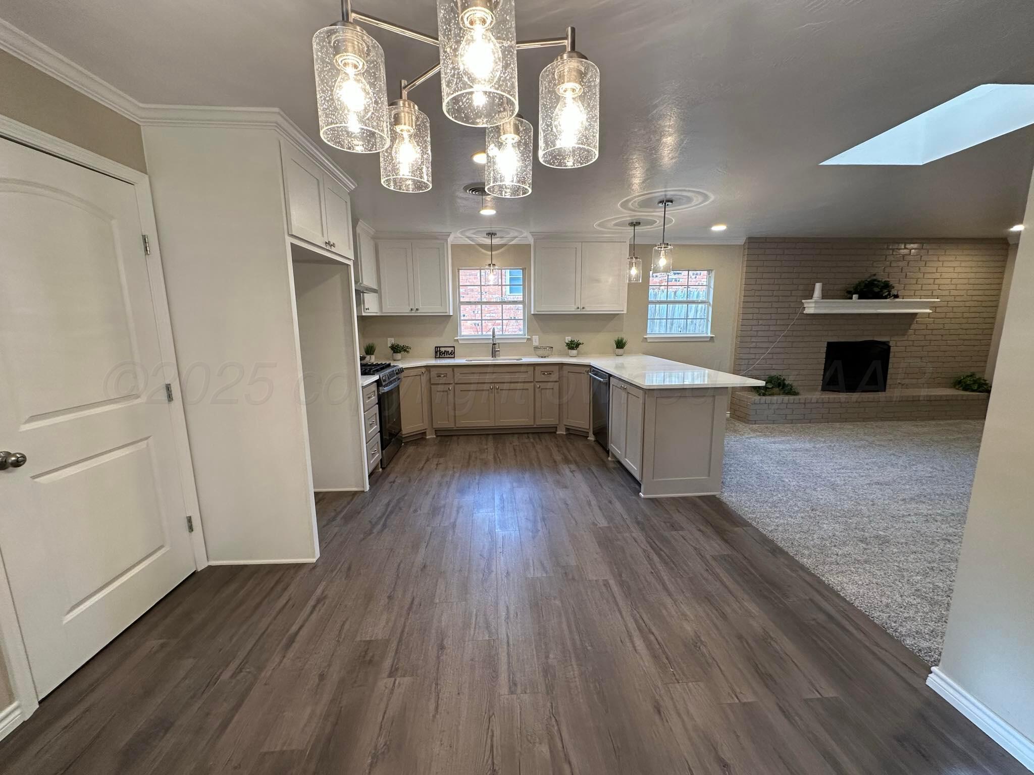 4402 Gary Lane Amarillo, TX 79110 - Photo 6 of 19 a large kitchen with cabinets wooden floor and stainless steel appliances