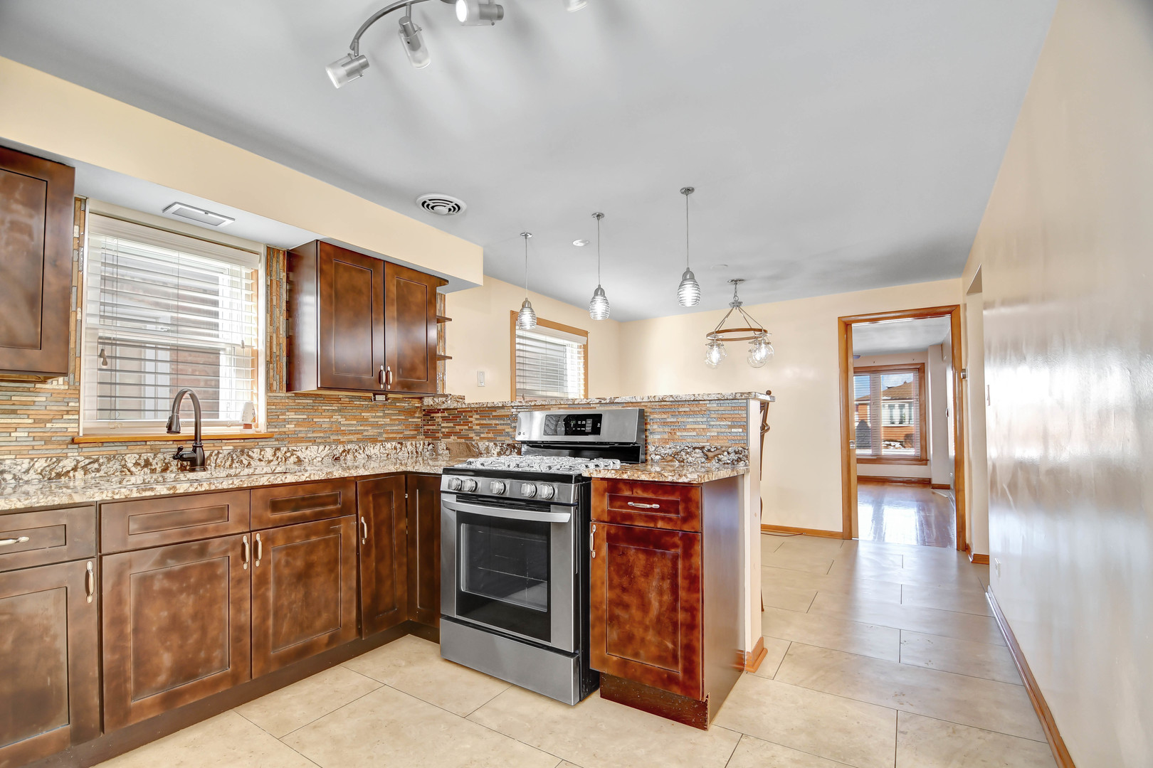 5927 West 64th Place Chicago, IL 60638 - Photo 7 of 23 a kitchen with stainless steel appliances granite countertop a stove and a sink