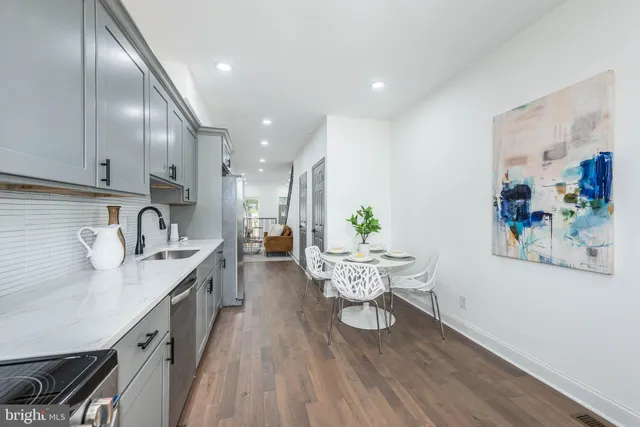 a kitchen with a dining table chairs and wooden floor