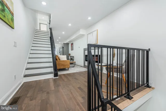 a view of a hallway with stairs and furniture