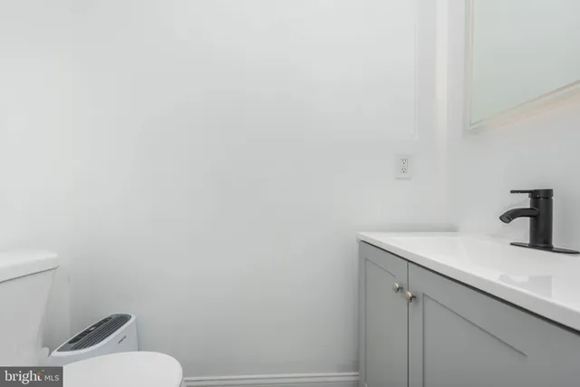 a bathroom with a granite countertop toilet and sink