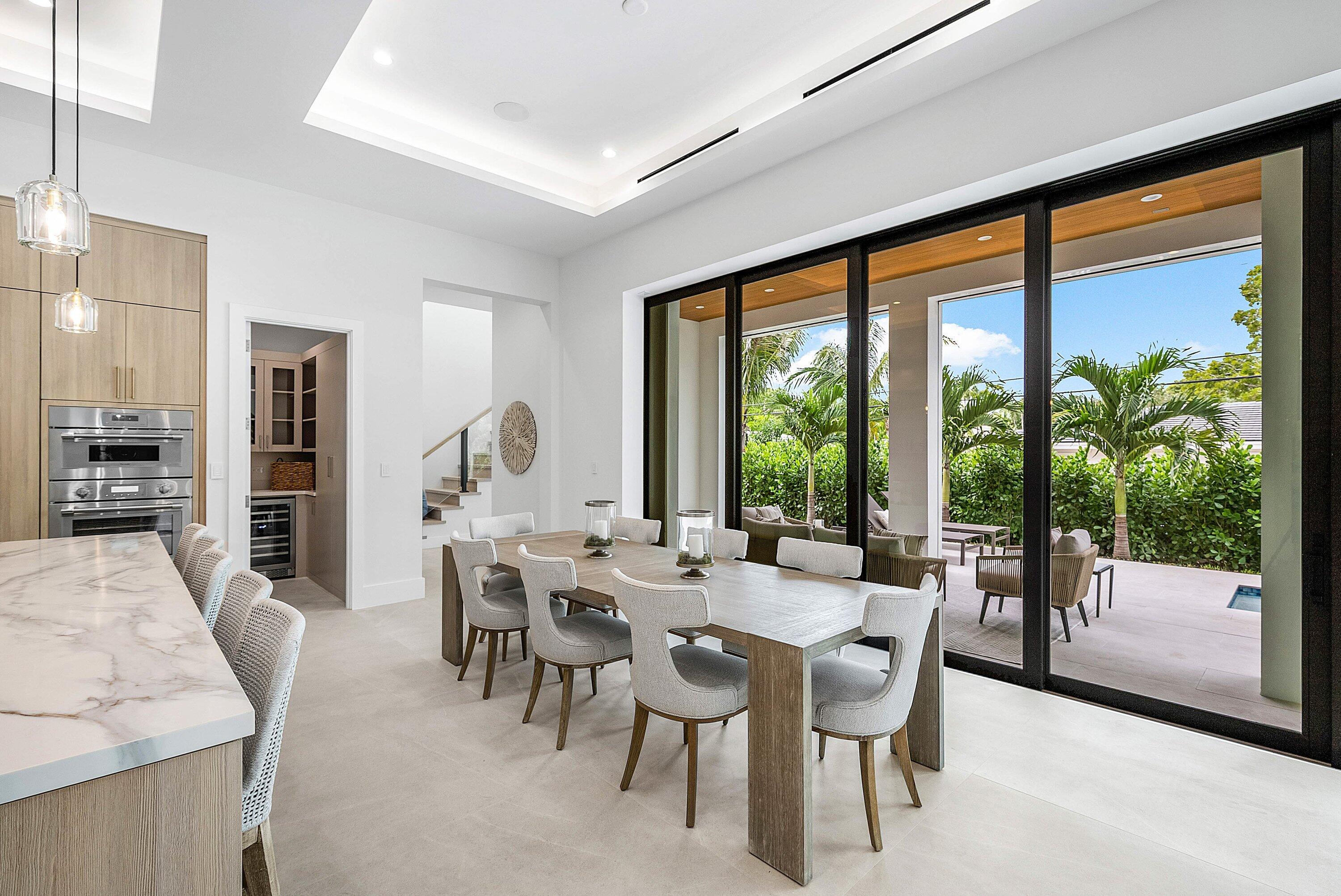 2609 Northeast 27th Way Fort Lauderdale, FL 33306 - Photo 14 of 53 a dining room with furniture large windows and a chandelier