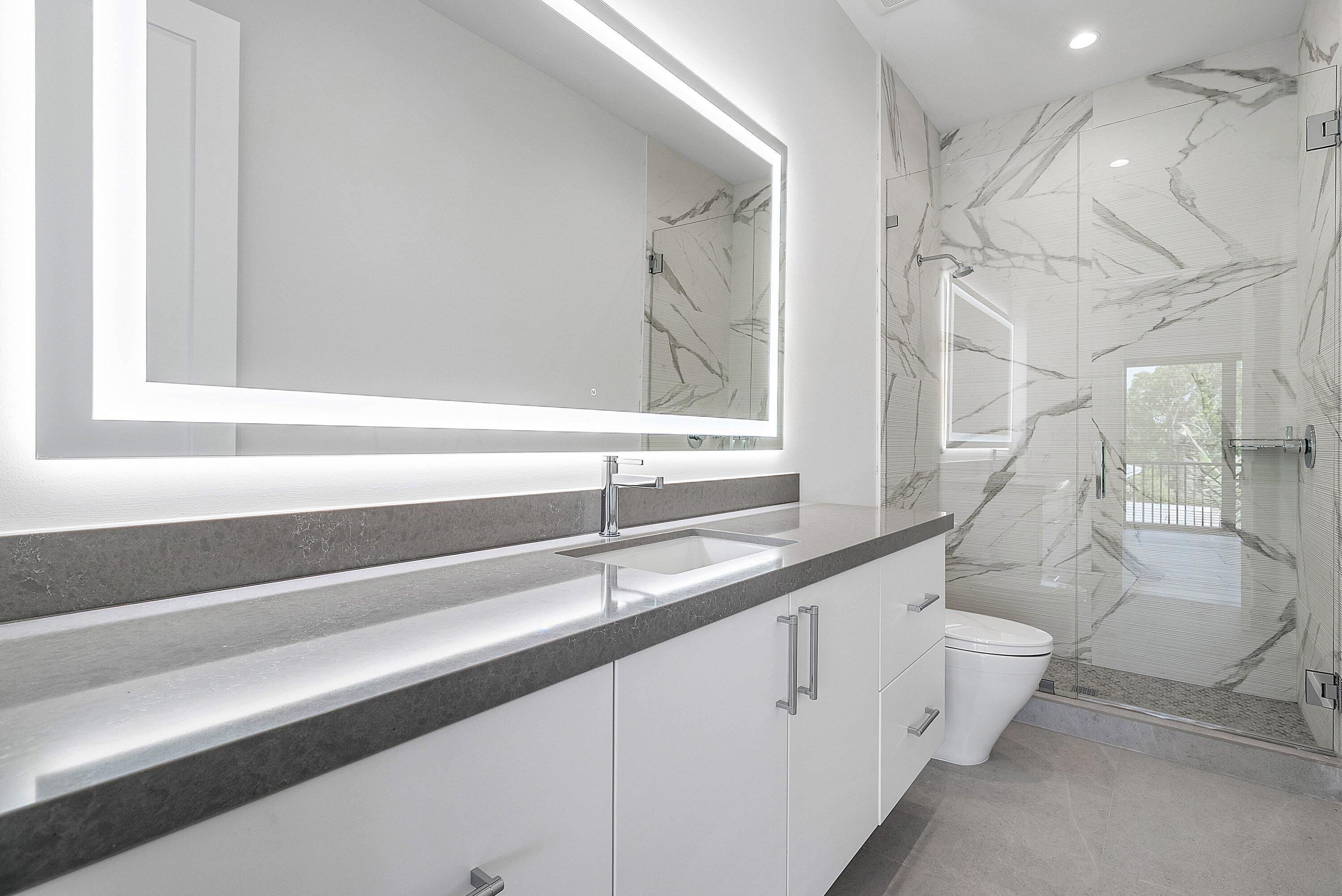 2609 Northeast 27th Way Fort Lauderdale, FL 33306 - Photo 45 of 53 a bathroom with a sink a toilet and a mirror