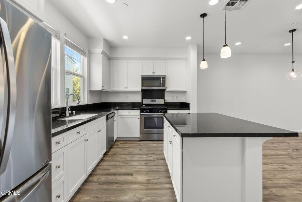 3705 Islander Walk Oxnard, CA 93035 - Photo 12 of 45 a kitchen with granite countertop a sink a counter top space stainless steel appliances and cabinets