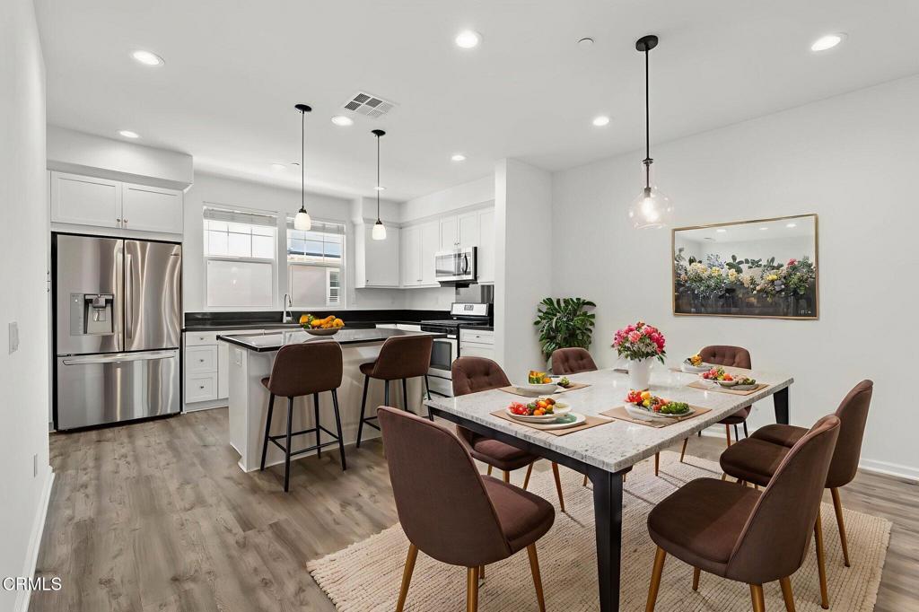 3705 Islander Walk Oxnard, CA 93035 - Photo 6 of 45 a kitchen with stainless steel appliances kitchen island a table and chairs in it
