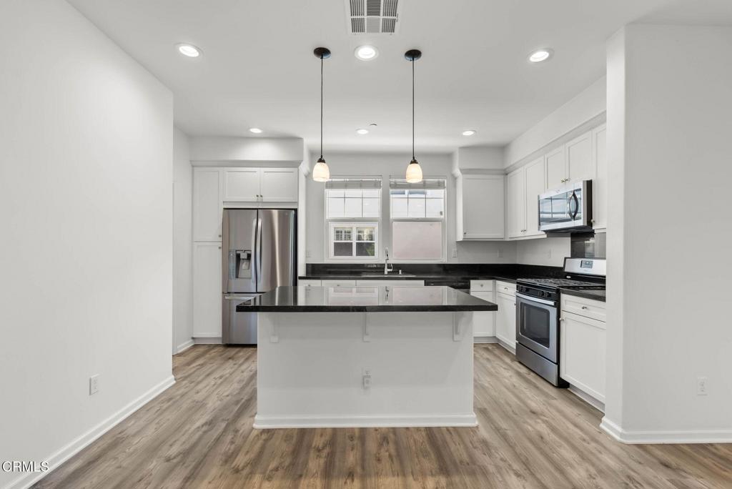 3705 Islander Walk Oxnard, CA 93035 - Photo 8 of 45 a kitchen with stainless steel appliances granite countertop a stove a sink and a refrigerator