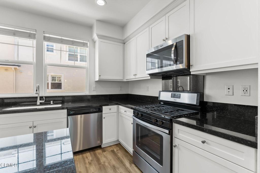 3705 Islander Walk Oxnard, CA 93035 - Photo 9 of 45 a kitchen with stainless steel appliances granite countertop a stove a sink and a microwave