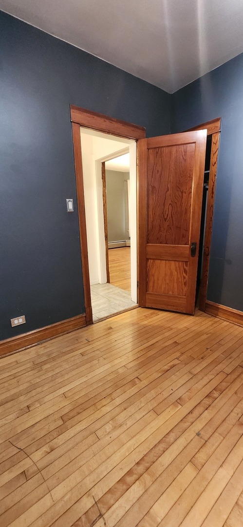 4450 West Altgeld Street, Unit 1 Chicago, IL 60639 - Photo 9 of 29 a view of an empty room with wooden floor and a window