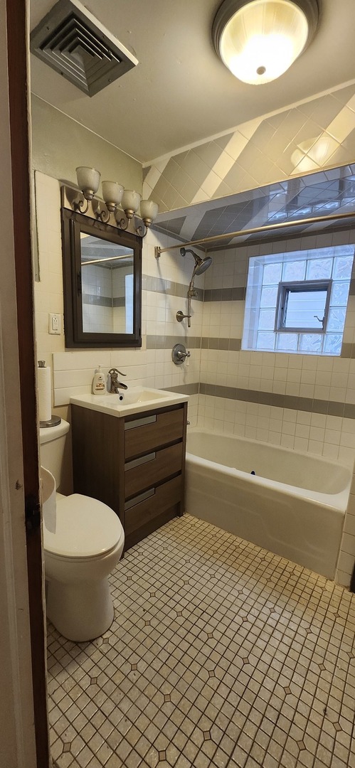 4450 West Altgeld Street, Unit 1 Chicago, IL 60639 - Photo 10 of 29 a bathroom with a toilet sink and mirror