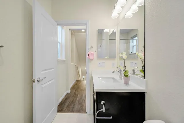 a kitchen with stainless steel appliances granite countertop a refrigerator a sink and wooden floors