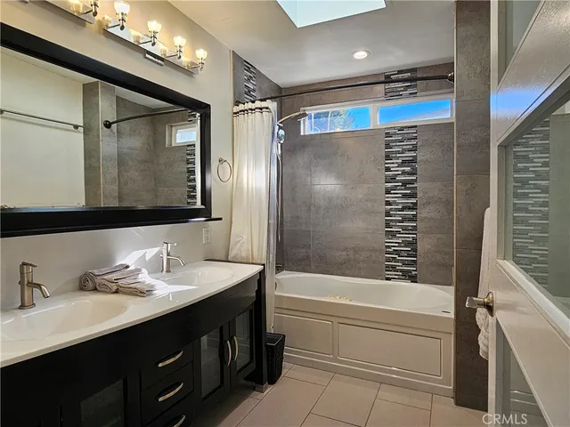 a bathroom with a double vanity sink mirror and shower