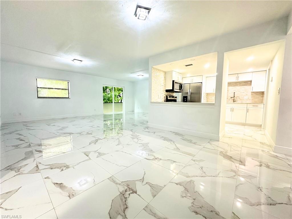 Undisclosed Address Naples, FL 34116 - Photo 2 of 16 a view of a livingroom with kitchen and furniture