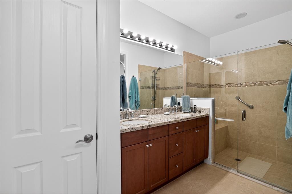 21044 Southwest Modena Way Port St. Lucie, FL 34986 - Photo 29 of 42 a bathroom with a double vanity sink mirror and shower