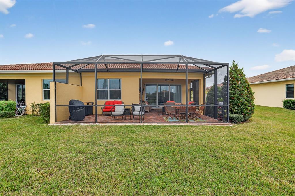 21044 Southwest Modena Way Port St. Lucie, FL 34986 - Photo 39 of 42 a view of a house with a patio and a yard