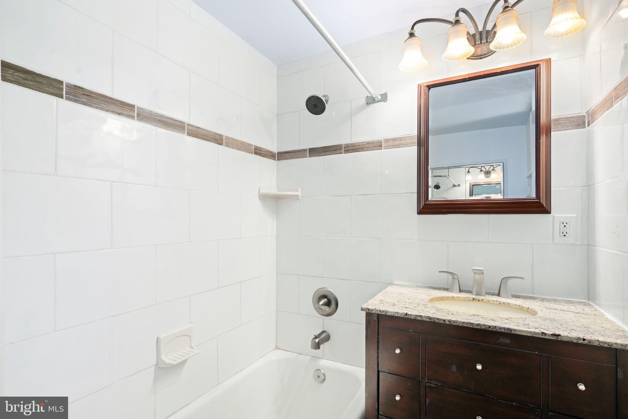 13 Rodney Road Bryn Mawr, PA 19010 - Photo 20 of 42 a bathroom with a granite countertop sink mirror and a bathtub