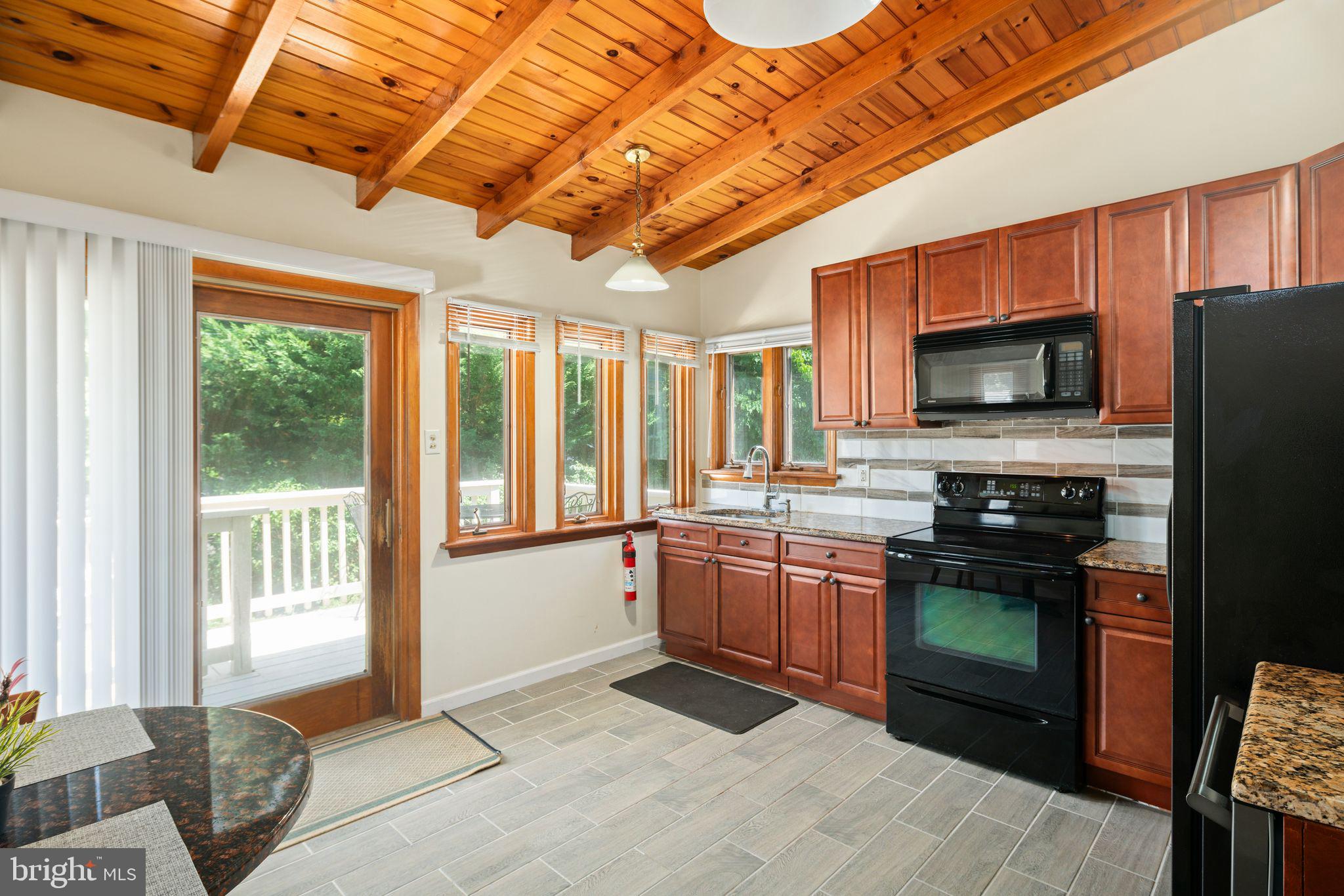 13 Rodney Road Bryn Mawr, PA 19010 - Photo 10 of 42 a kitchen with stainless steel appliances granite countertop a stove top oven a sink dishwasher a dining table and chairs with wooden floor