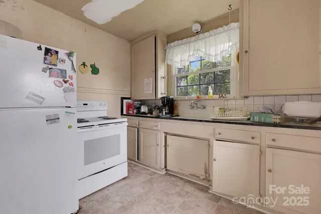 a kitchen with granite countertop white cabinets and white appliances