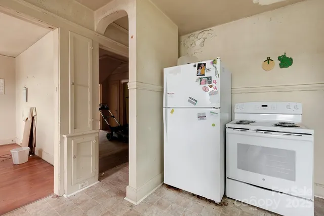 a white refrigerator freezer and a stove sitting inside of a kitchen