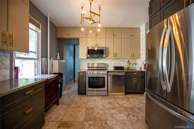 a kitchen with granite countertop a refrigerator and a stove top oven