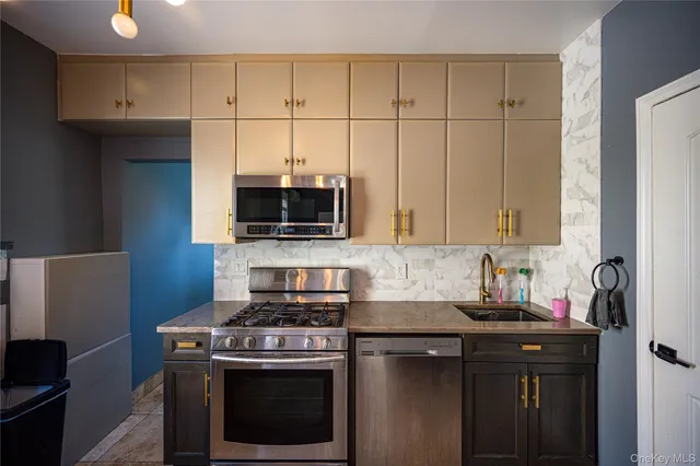 a kitchen with stainless steel appliances a sink a stove and microwave