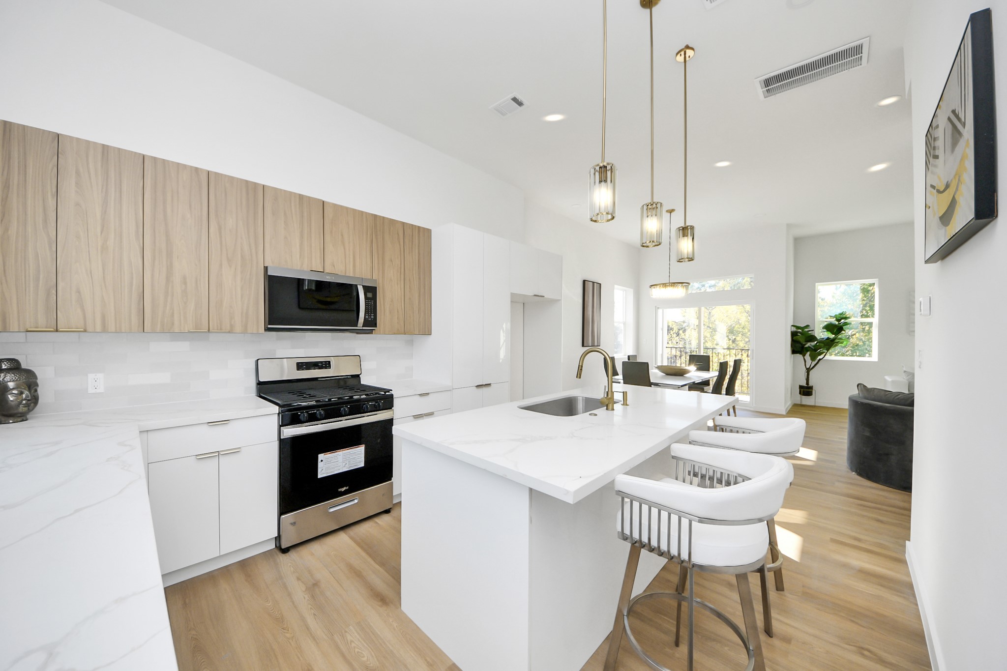 1216 East 34th Street, Unit B Houston, TX 77022 - Photo 19 of 42 a kitchen with stainless steel appliances kitchen island granite countertop a sink a stove a dining table and chairs